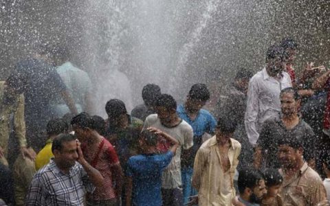 people cool off from the heat as they are sprayed with water jetting out from a leaking water pipeline in karachi pakistan june 25 2015 photo reuters