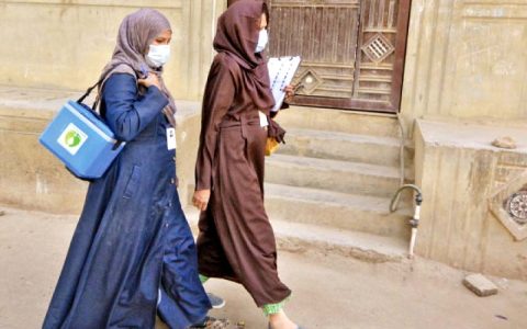 polio vaccinators carrying bag of vaccines and documents to collect data walk through a neighbourhood in karachi at the start of a nationwide inoculation drive photo jalal qureshi express