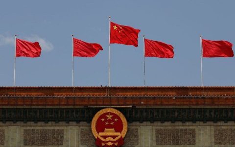 chinese flag flutters above the chinese national emblem at the great hall of the people in beijing china may 22 2020 photo reuters